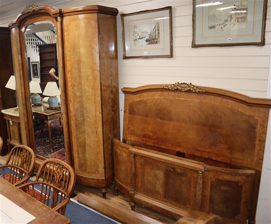 An early 20th century French tulip-banded walnut three piece bedroom suite comprising mirrored knockdown armoire, 46 bedframe, a ma